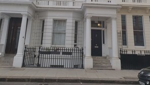 A multi-story building with a classic architectural style, featuring symmetrical windows and decorative moldings. - Studio Apartment in South Kensington 16 (London)