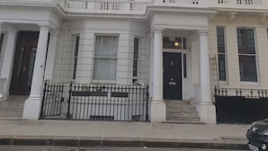 A multi-story building with a classic architectural style, featuring symmetrical windows and decorative moldings.