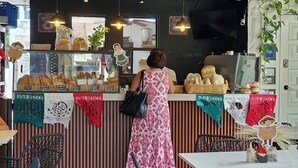 Een café interieur met een toonbank vol gebak, een plafondventilator en een patroon vloer.