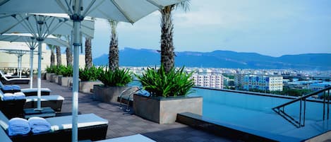 Piscine extérieure, parasols de plage, chaises longues