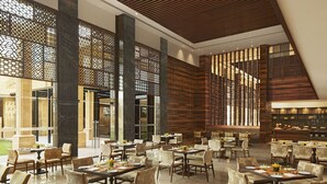 Un vaste espace dédié à la salle à manger, avec de nombreuses tables et chaises, de grandes fenêtres et un aménagement intérieur moderne.