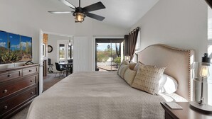 A bedroom with a bed, a desk, a ceiling fan, and a view of the outdoors. - Upscale Private Home In A Quite Gated Community With Breathtaking Mountain Views (Tucson)