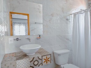 Un bagno con lavandino, WC e tenda della doccia bianca.