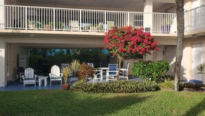 A two-story building with a balcony, outdoor seating area, and a well-maintained garden.