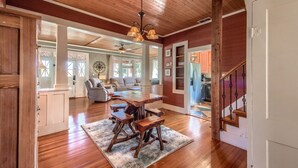 A spacious living area with a wooden dining table and chairs, a ceiling fan, and a staircase. - Star Haus DT 292 5 Bedroom Home by RedAwning (New Braunfels)
