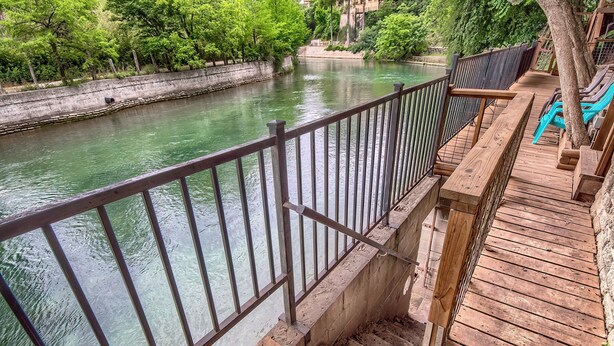 A wooden deck with a metal railing overlooking a river. - Star Haus DT 292 5 Bedroom Home by RedAwning (New Braunfels)