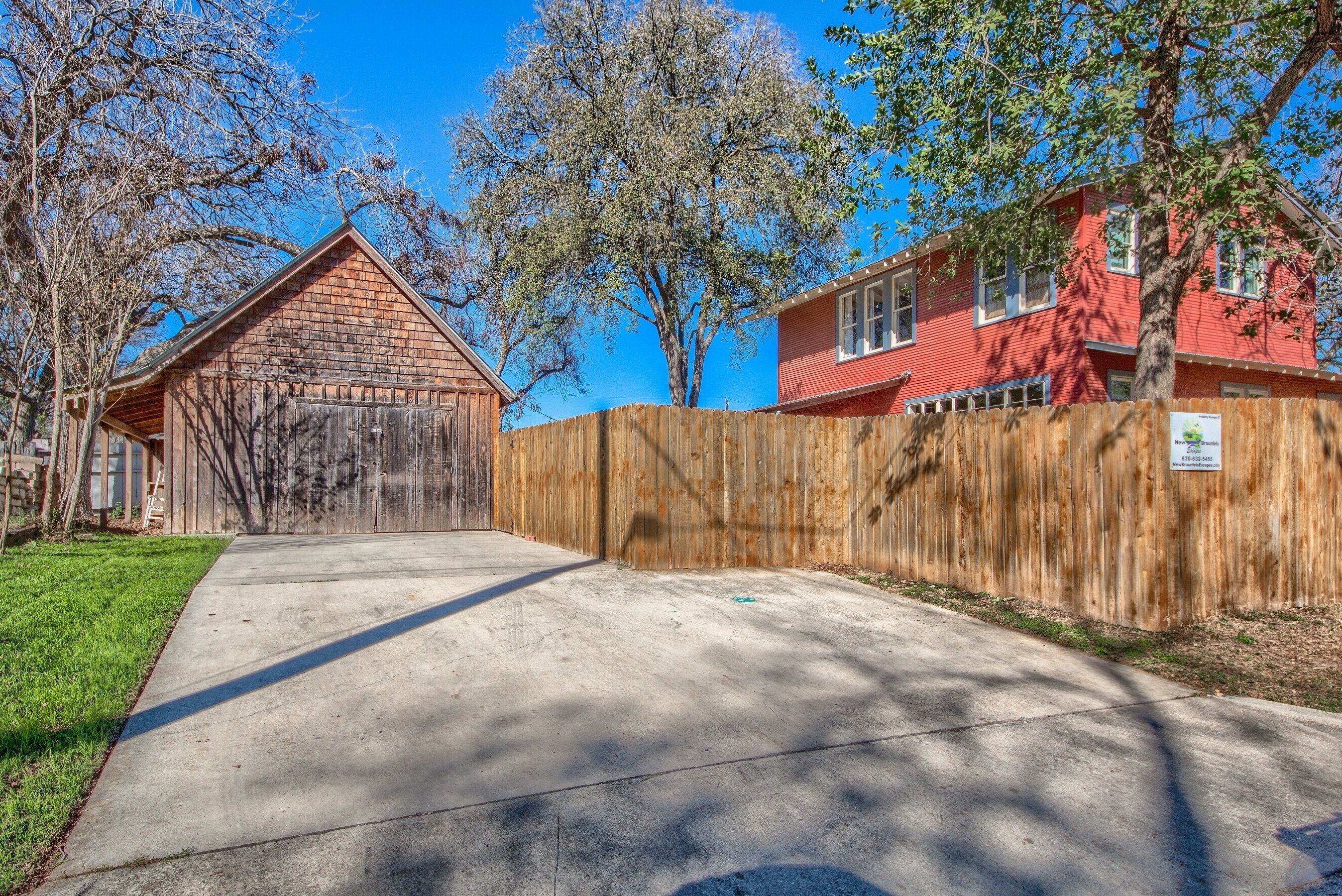Il s’agit d’une propriété résidentielle comprenant un garage en bois, une maison rouge et une clôture en bois.