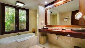 Een aparte badkuip en douche, een haardroger, handdoeken, zeep