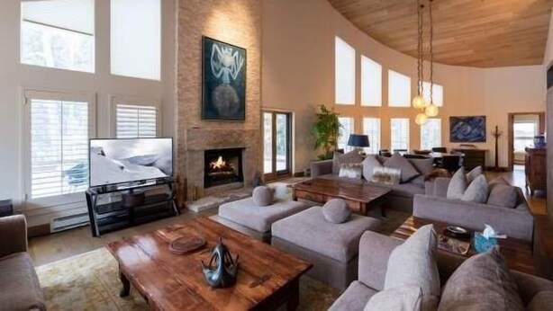 A spacious living room with a fireplace, comfortable seating, and large windows. - Northwoods Private Penthouse with Effortless Ski-In Ski-Out Access by RedAwning (Vail)