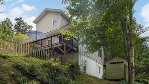 Une maison à deux étages avec une terrasse et un garage.