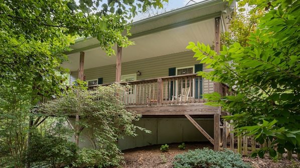 Un bâtiment à deux étages doté d’une terrasse en bois et d’un espace extérieur abrité.