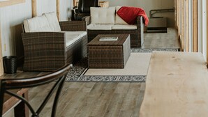 Una habitación acogedora con muebles de mimbre, un ventilador de techo y una mesa de madera.