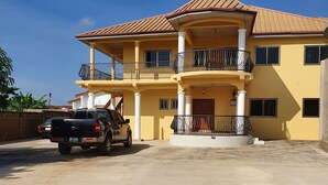 A multi-story building with balconies and a clear blue sky. - 2 bedroom apartment (North Legon)