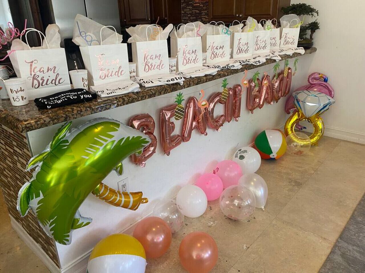A reception area with a 'Team Bride' sign, balloons, and party favors.
