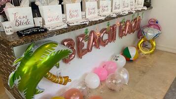 A reception area with a 'Team Bride' sign, balloons, and party favors.