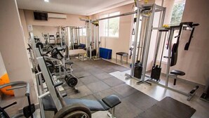 A gym with various exercise equipment, including weight machines and free weights. - Nayru Hotel (Toledo)