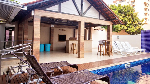 A covered pool area with lounge chairs, a bar, and a seating area. - Nayru Hotel (Toledo)