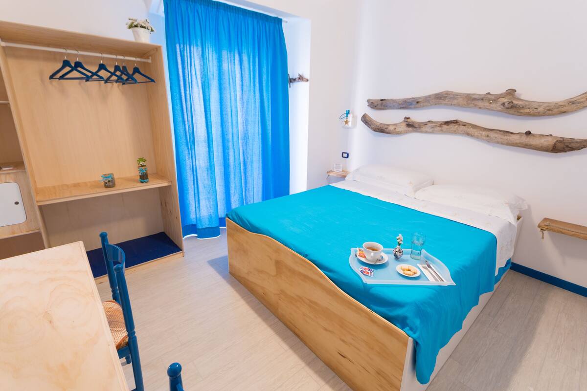 Une chambre à coucher avec un lit, une armoire en bois, une table et une chaise.