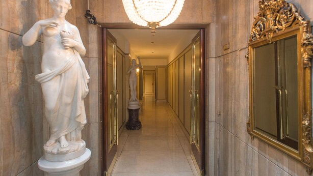 A marble hallway with statues, a chandelier, and ornate doors. - Apartment Rod Pena By Hart (Buenos Aires)