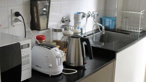 A kitchen with a toaster, kettle, and coffee maker on the counter. - Apartment Rod Pena By Hart (Buenos Aires)