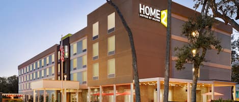 Un hôtel moderne avec une enseigne indiquant « HOME 2 SUITES BY HILTON ».