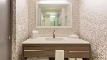 A bathroom with a white sink, a mirror, and a towel rack.