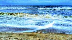 A beach with waves crashing onto the shore under a cloudy sky. - Home2 Suites by Hilton Fernandina Beach Amelia Island, FL (Fernandina Beach)