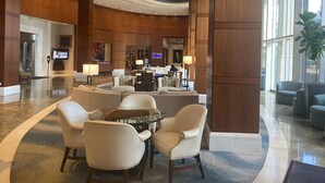 A spacious lobby with a reception desk, comfortable seating area, and large windows allowing natural light.