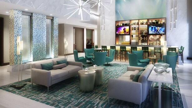 A modern lobby with a bar area, seating arrangements, and a large screen. - Wyndham Garden Miami International Airport (Miami Springs)