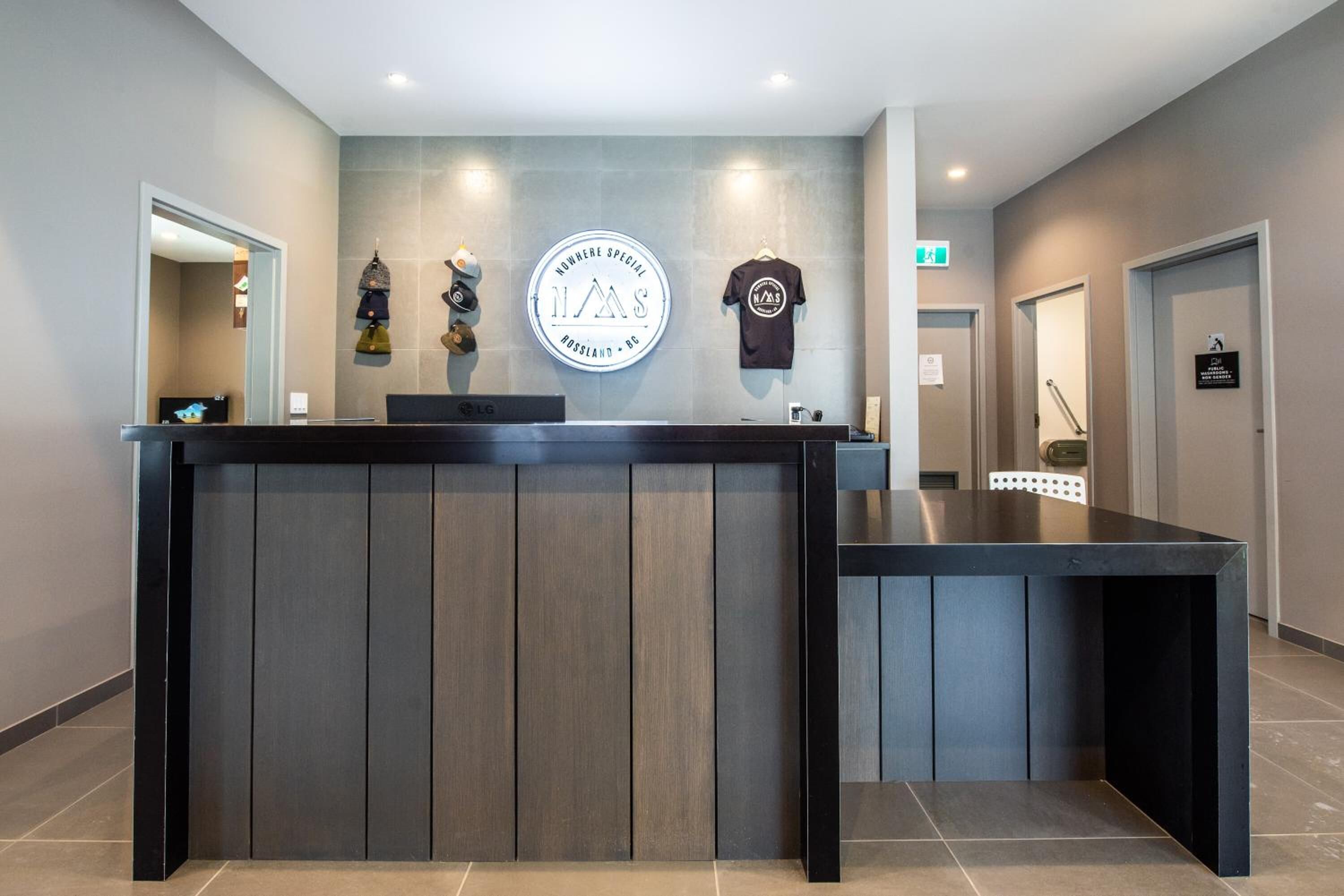 Un mostrador de recepción de diseño moderno, un logotipo circular en la pared y un cartel que indica una tarifa especial.