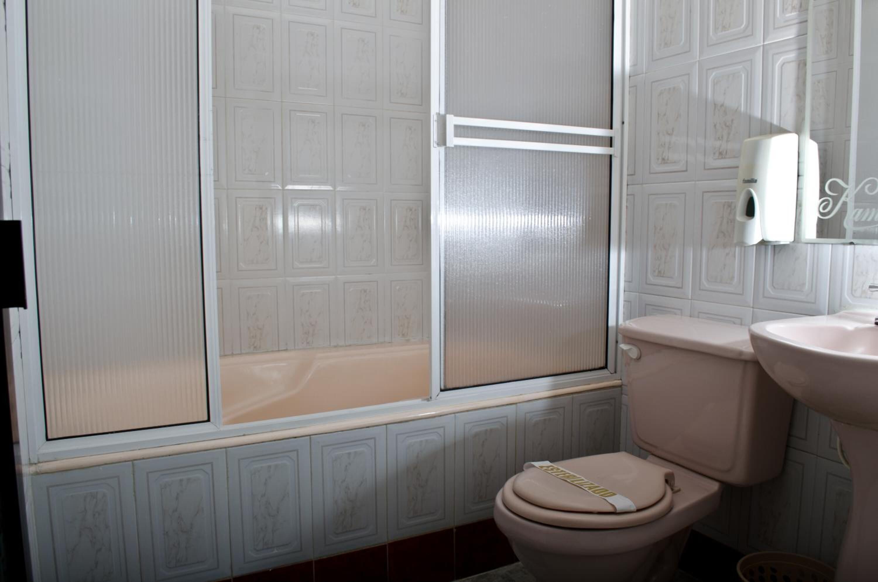Un baño con inodoro, lavamanos y cabina de ducha.