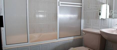Un baño con inodoro, lavamanos y cabina de ducha.