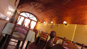 A restaurant with brick ceiling, wooden chairs, and tables. - Locanda alla stazione (Mira)