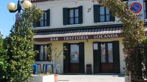A building with a sign reading "BAR TRATTORIA LOCANDA" and a no parking sign. - Locanda alla stazione (Mira)