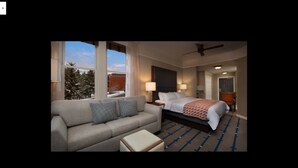 A hotel room with a bed, a sofa, a nightstand, and a window with a view of trees. - Marriott Summit Watch, Beautiful 1 BR, 1bath Villa, Ski in/Ski out 11/23-30/19 (Park City)