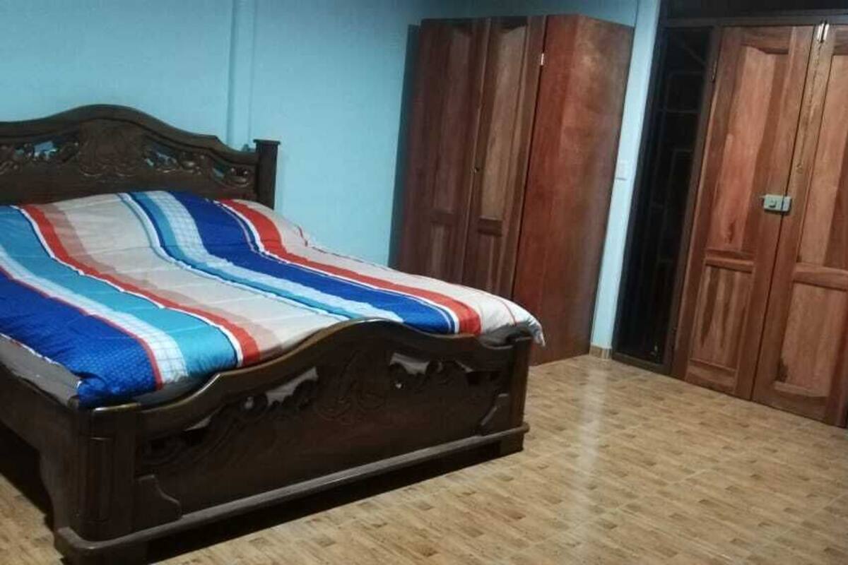 Ein Schlafzimmer mit einem hölzernen Bett, einem Schrank und einer Tür.