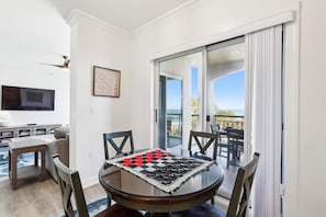 A dining area with a glass table, chairs, and a checkered board game.