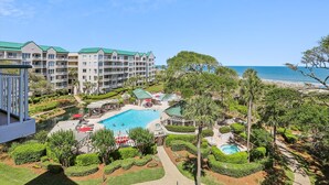 Ein Resort mit mehreren Gebäuden, einem Pool und Blick auf den Strand.
