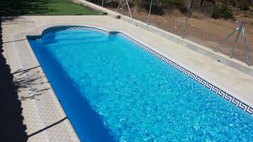 Una piscina rectangular con borde de azulejos y superficie de agua azul cristalina.