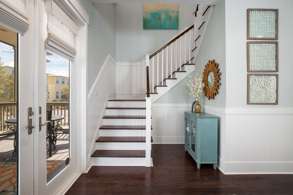 A staircase with white railings and dark wooden steps leading to a landing.