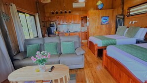 Un intérieur de chalet chaleureux comprenant un espace de vie, une cuisine et une chambre.