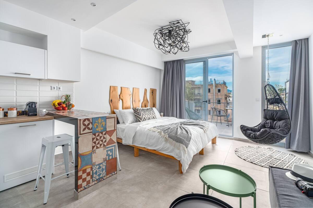 Un apartamento moderno con cocina, cama, comedor y balcón.
