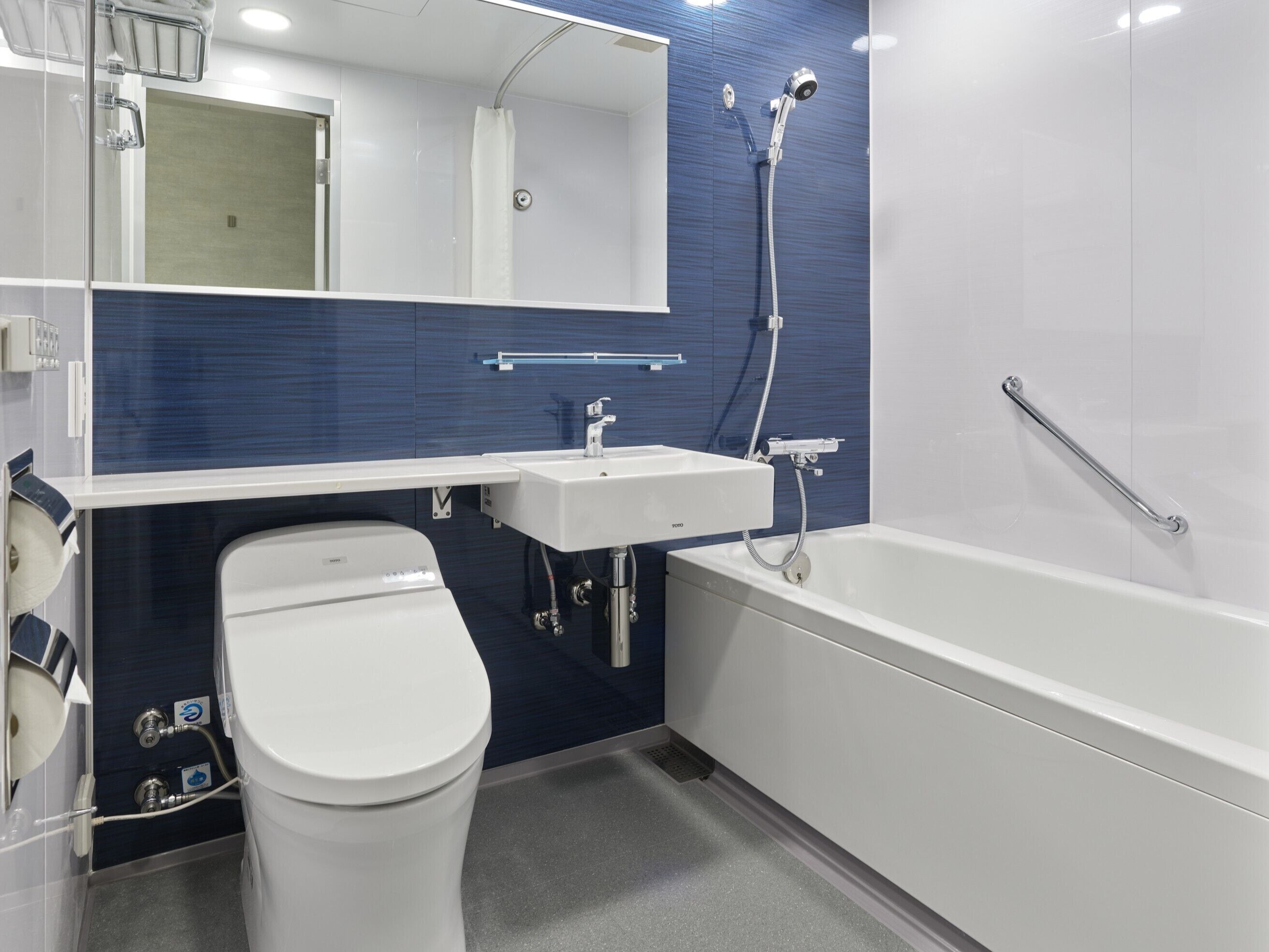 A modern bathroom with a white toilet, a sink, and a bathtub.