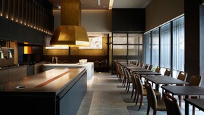 A modern restaurant with a long counter, high ceiling, and large windows. - Mitsui Garden Hotel Fukuoka Nakasu (Fukuoka)