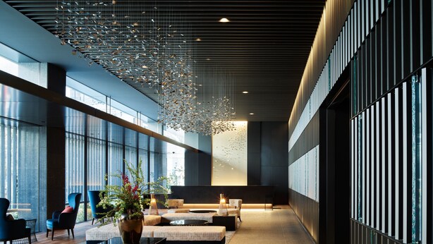 A spacious lobby with modern furnishings, a hanging light installation, and large windows allowing natural light. - Mitsui Garden Hotel Fukuoka Nakasu (Fukuoka)