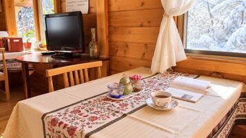 A cozy room with a wooden interior, a table set with a cup of tea, a book, and a teapot.