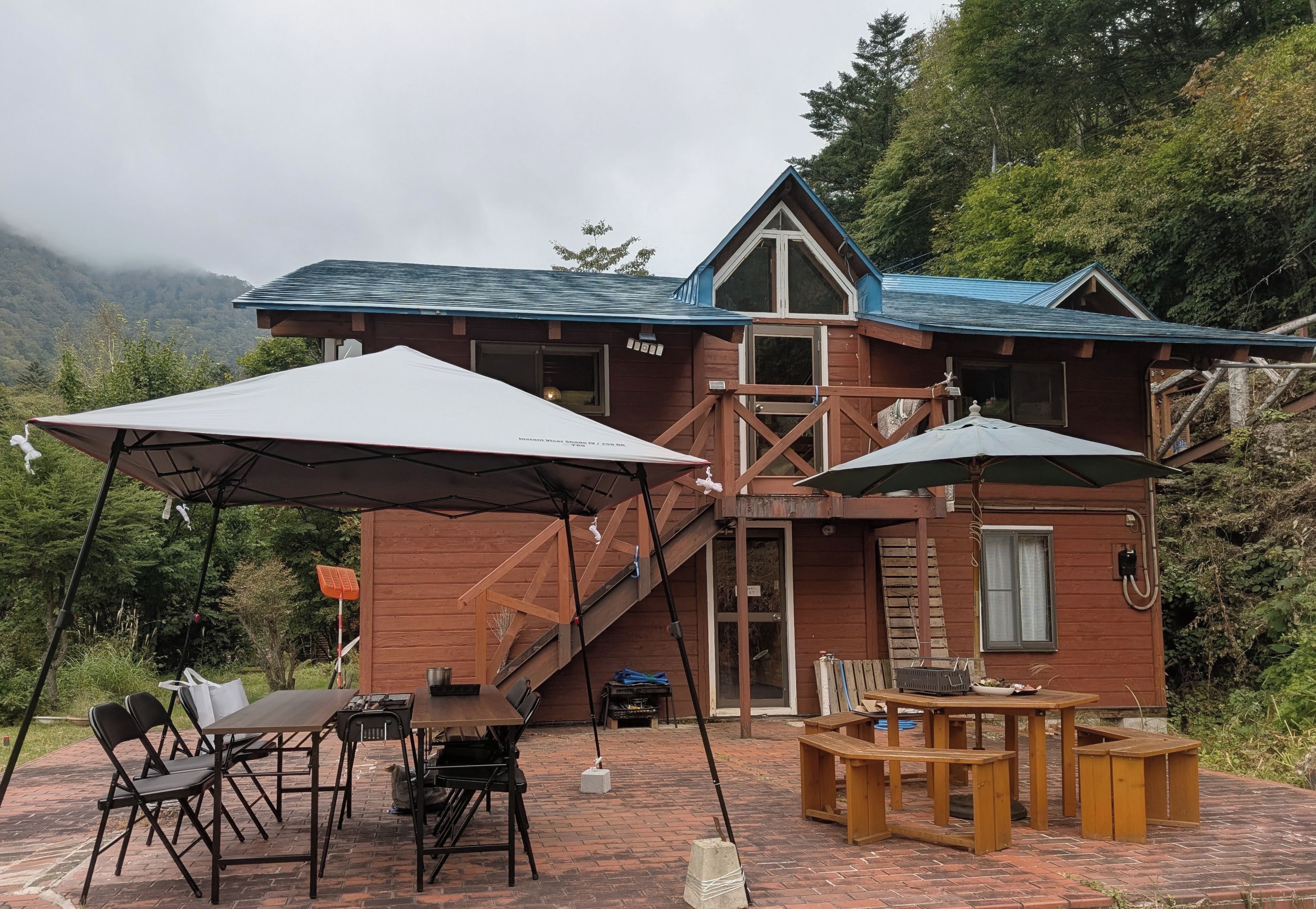 Eine Holzhütte mit Balkon, Sitzgelegenheiten im Freien und einer überdachten Terrasse.