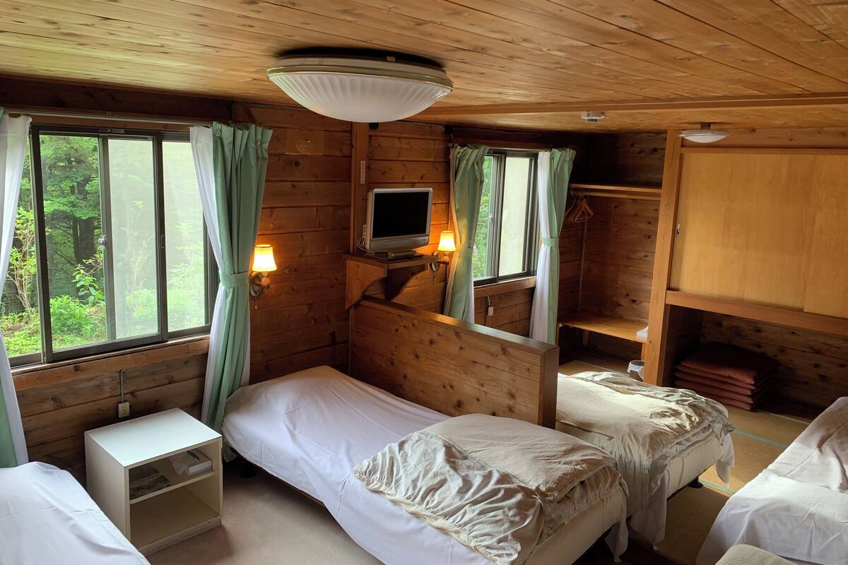 A cabin room with two beds, a TV, and a wardrobe.