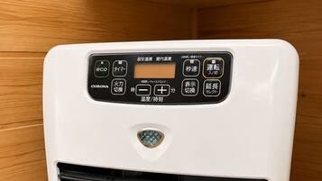 A white portable air conditioner with a control panel, placed on a wooden surface.