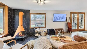 En hyggelig stue med pejs, behagelige siddepladser og et fjernsyn.